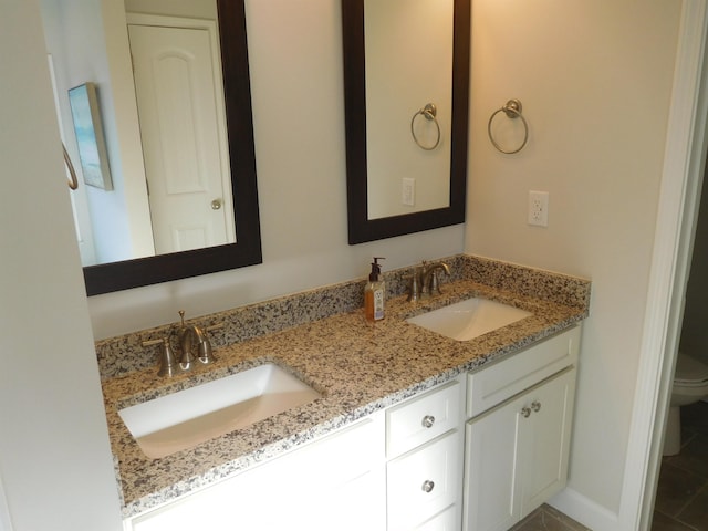 bathroom featuring toilet, tile patterned flooring, and vanity