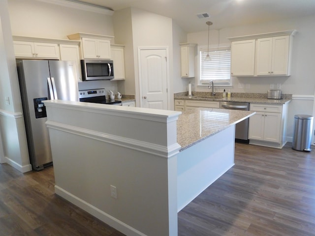 kitchen with white cabinets, pendant lighting, appliances with stainless steel finishes, and a center island