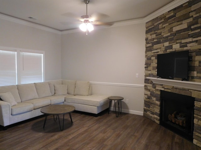 living room featuring ceiling fan, dark hardwood / wood-style flooring, crown molding, and a stone fireplace