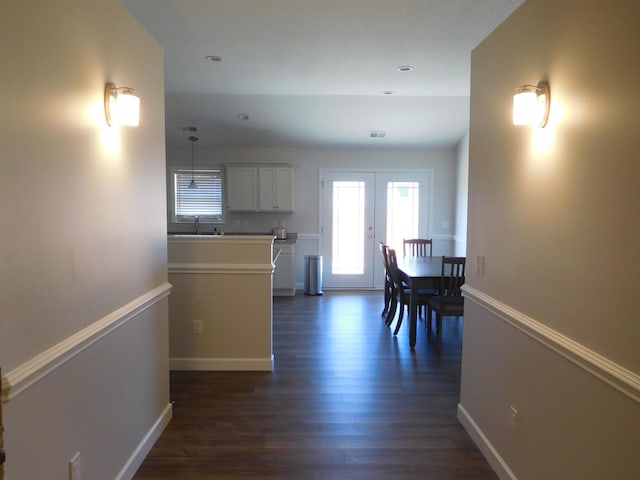 corridor with sink, french doors, and dark wood-type flooring