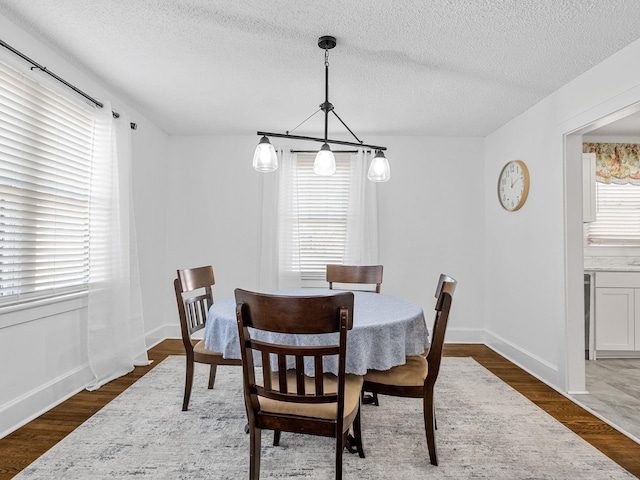 dining area with dark hardwood / wood-style floors and a textured ceiling