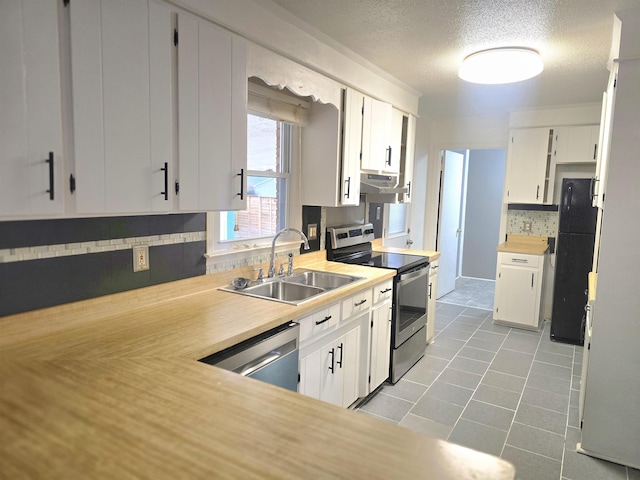 kitchen featuring white cabinets, stainless steel appliances, sink, light tile patterned floors, and range hood