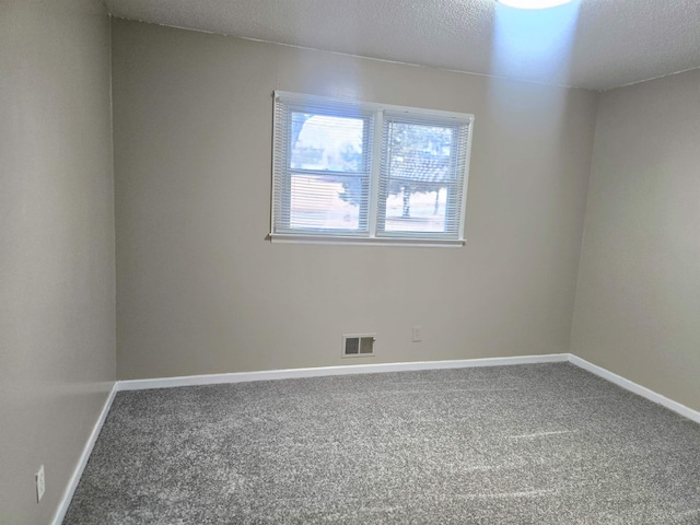 carpeted spare room with a textured ceiling