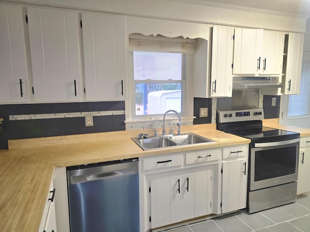 kitchen with sink, white cabinetry, light tile patterned floors, and stainless steel appliances