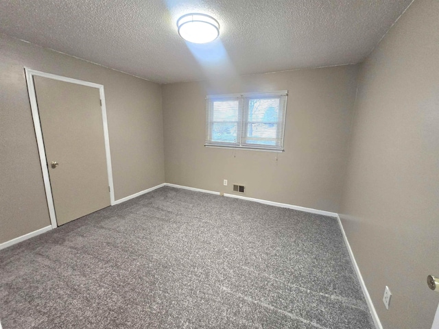 carpeted spare room with a textured ceiling