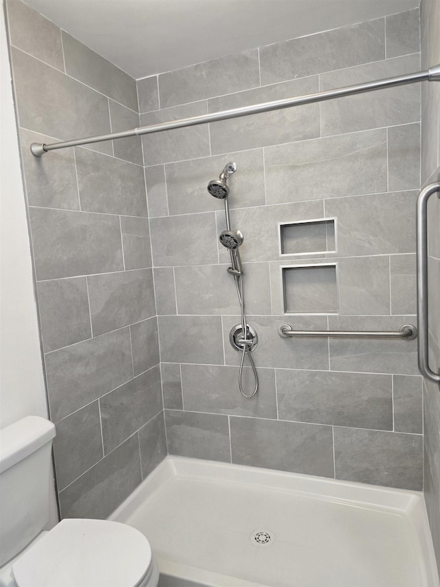 bathroom with toilet and a tile shower