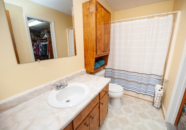 bathroom featuring vanity, toilet, and curtained shower