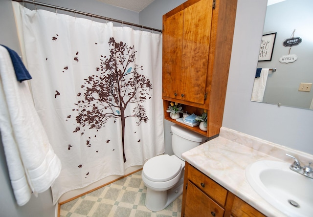 bathroom featuring toilet, vanity, and walk in shower