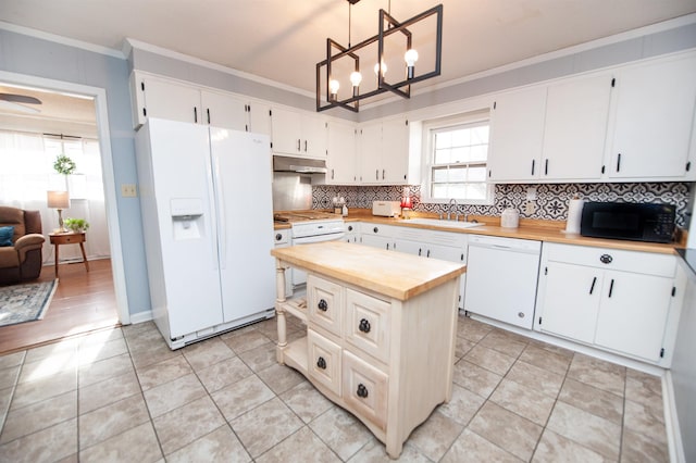 kitchen featuring white appliances, hanging light fixtures, white cabinets, sink, and ornamental molding