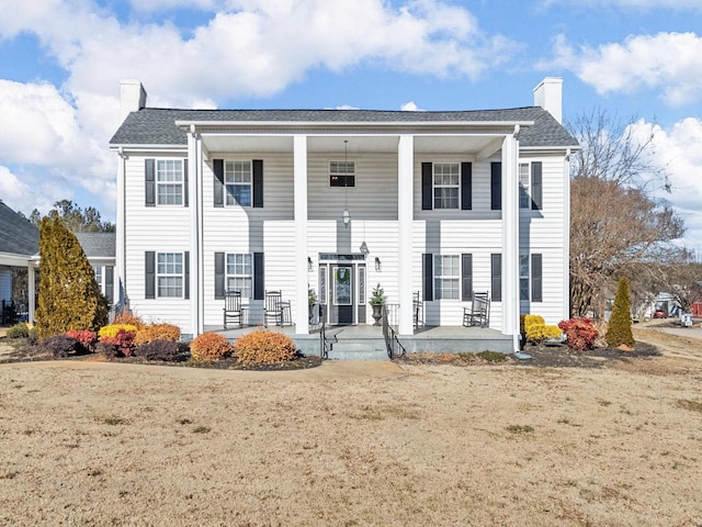 view of front of house featuring covered porch and a front lawn