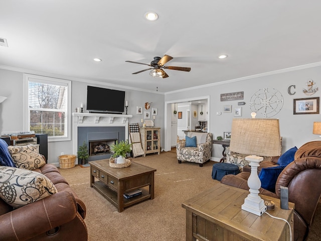 living room featuring ceiling fan, ornamental molding, and carpet flooring