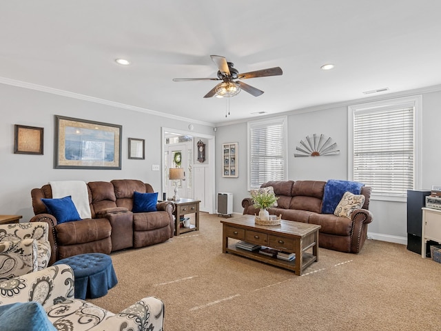 living room with crown molding, ceiling fan, and light carpet