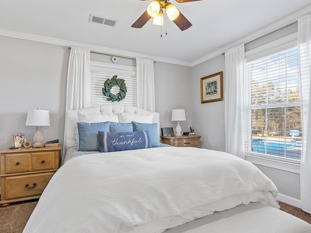 carpeted bedroom with ornamental molding and ceiling fan