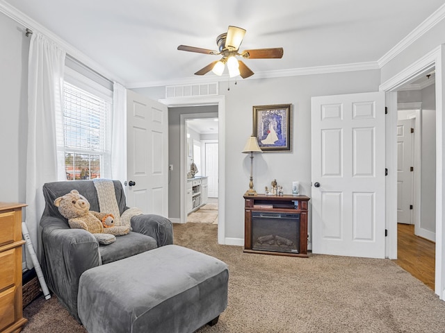 sitting room with crown molding, ceiling fan, and carpet flooring