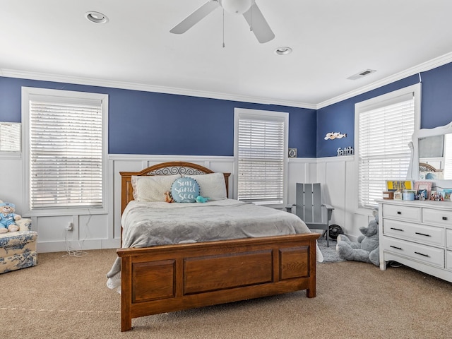 carpeted bedroom with multiple windows, crown molding, and ceiling fan