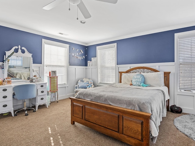 carpeted bedroom with ornamental molding and ceiling fan