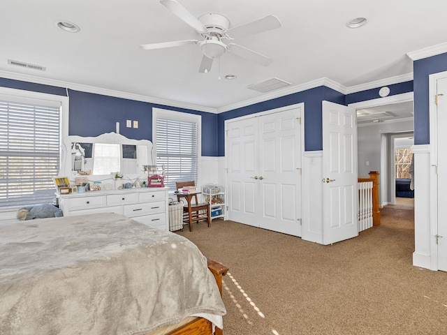 bedroom with ornamental molding, a closet, ceiling fan, and carpet flooring