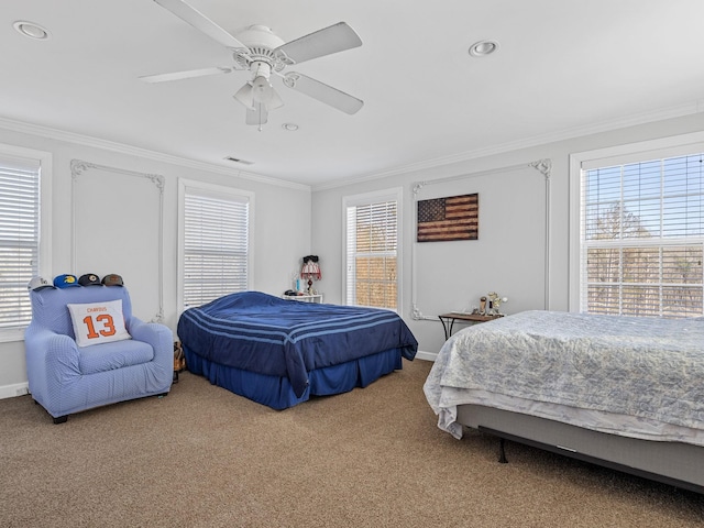 carpeted bedroom featuring crown molding and ceiling fan