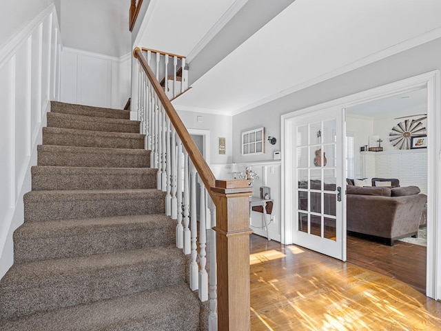 stairs featuring crown molding, hardwood / wood-style floors, and french doors