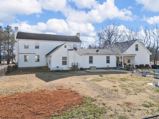 rear view of property with cooling unit and a patio area