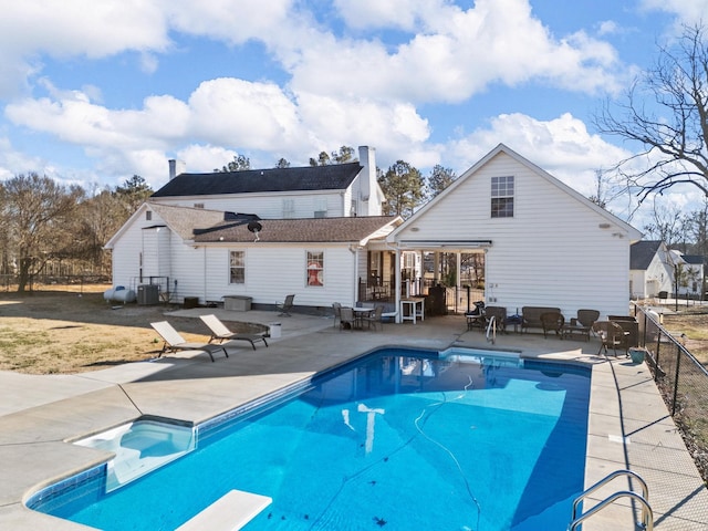 view of swimming pool with a diving board, central AC unit, and a patio area