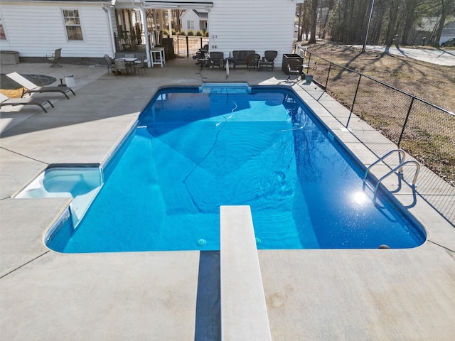 view of swimming pool with a diving board and a patio area