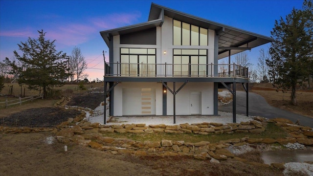 back house at dusk featuring a deck