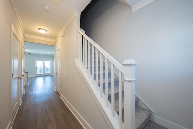 stairway with ornamental molding and wood-type flooring