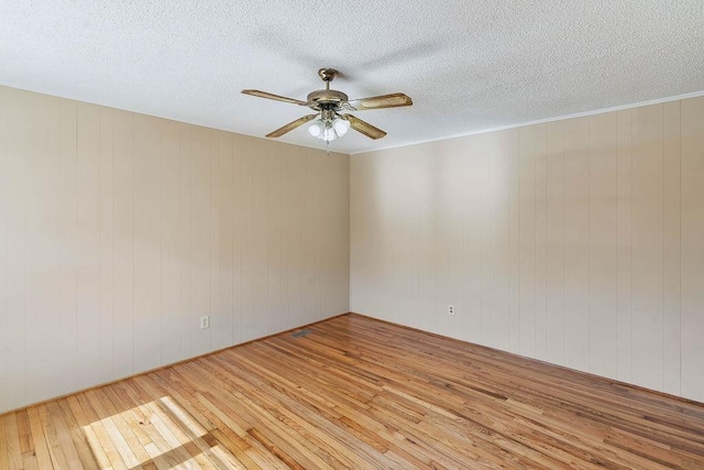 empty room with light wood-type flooring and wood walls