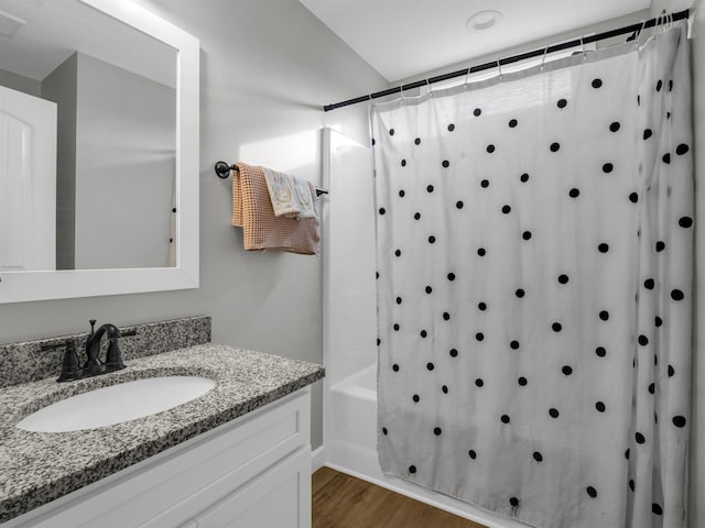 bathroom featuring hardwood / wood-style flooring, vanity, and shower / tub combo with curtain