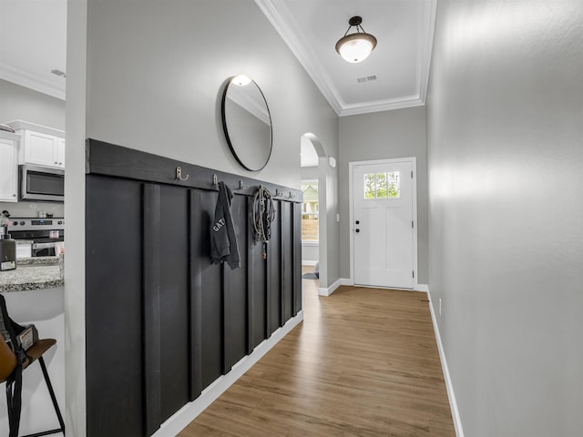 doorway to outside featuring crown molding and light hardwood / wood-style flooring