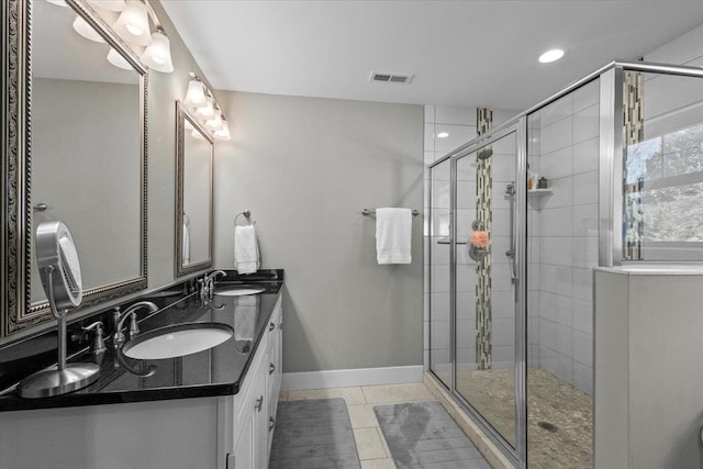 bathroom featuring tile patterned flooring, vanity, and walk in shower