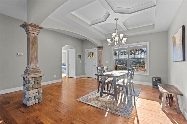 dining space with ornate columns, coffered ceiling, hardwood / wood-style floors, and a chandelier