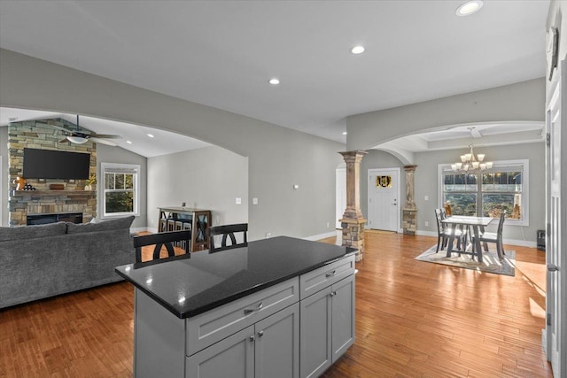 kitchen featuring a healthy amount of sunlight, light wood-type flooring, a kitchen island, and gray cabinetry