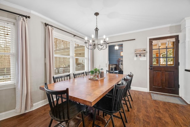 dining space featuring crown molding, a barn door, a notable chandelier, and dark hardwood / wood-style flooring