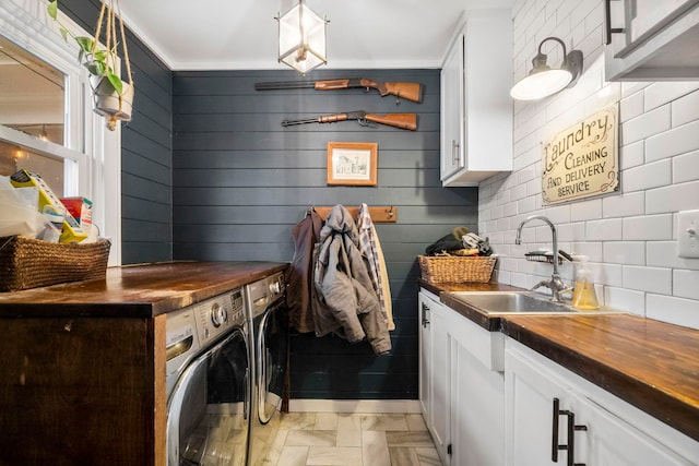 laundry area featuring sink, washing machine and dryer, and cabinets