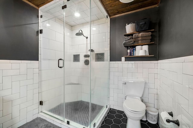 bathroom with tile patterned floors, toilet, an enclosed shower, wood ceiling, and tile walls