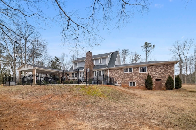 back of house with a carport and a yard