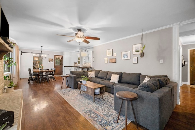 living room with crown molding, dark wood-type flooring, and ceiling fan with notable chandelier