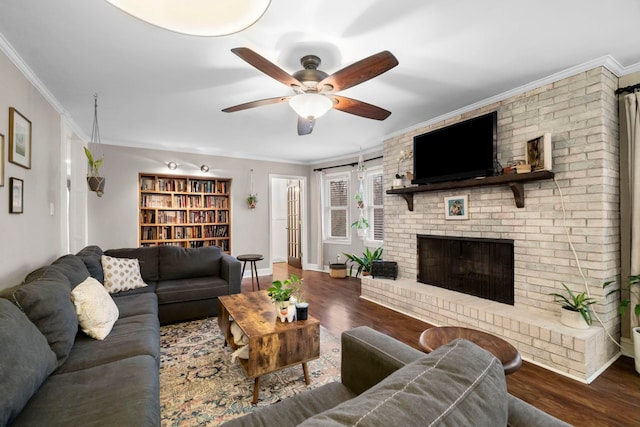 living room featuring crown molding, ceiling fan, dark hardwood / wood-style floors, and a brick fireplace