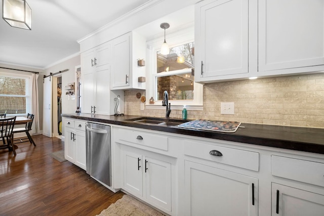 kitchen with white cabinetry, sink, stainless steel dishwasher, and a barn door