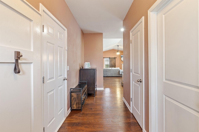 corridor with vaulted ceiling and dark hardwood / wood-style floors