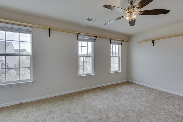 carpeted spare room featuring ceiling fan