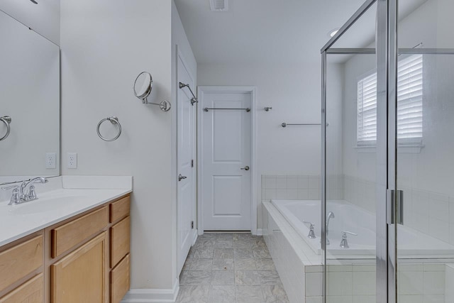 bathroom featuring a relaxing tiled tub and vanity