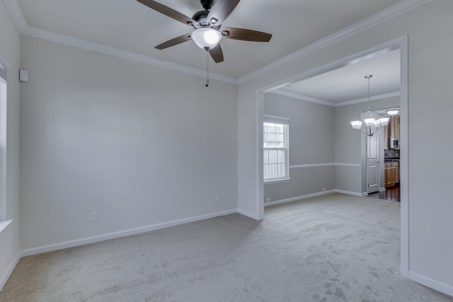 carpeted spare room featuring crown molding and ceiling fan with notable chandelier