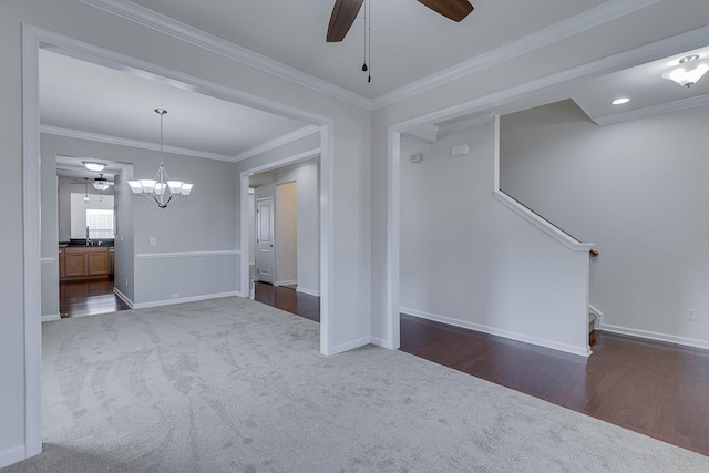 unfurnished room with dark colored carpet, crown molding, and ceiling fan with notable chandelier