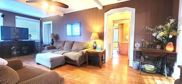 living room with beamed ceiling, ceiling fan, and light hardwood / wood-style flooring