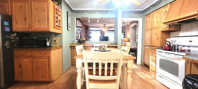 kitchen featuring ceiling fan, premium range hood, backsplash, black appliances, and light hardwood / wood-style floors