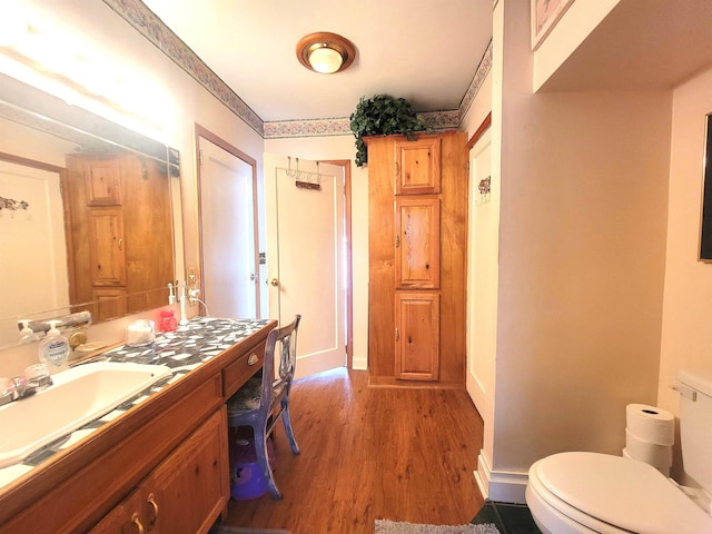 bathroom with hardwood / wood-style flooring, vanity, and toilet