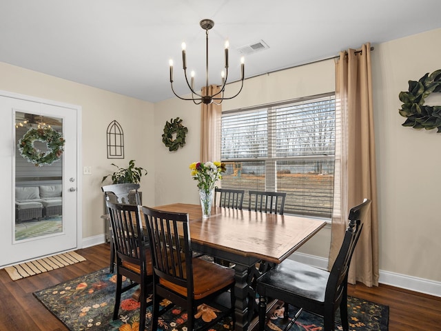 dining space featuring a notable chandelier and dark wood-type flooring